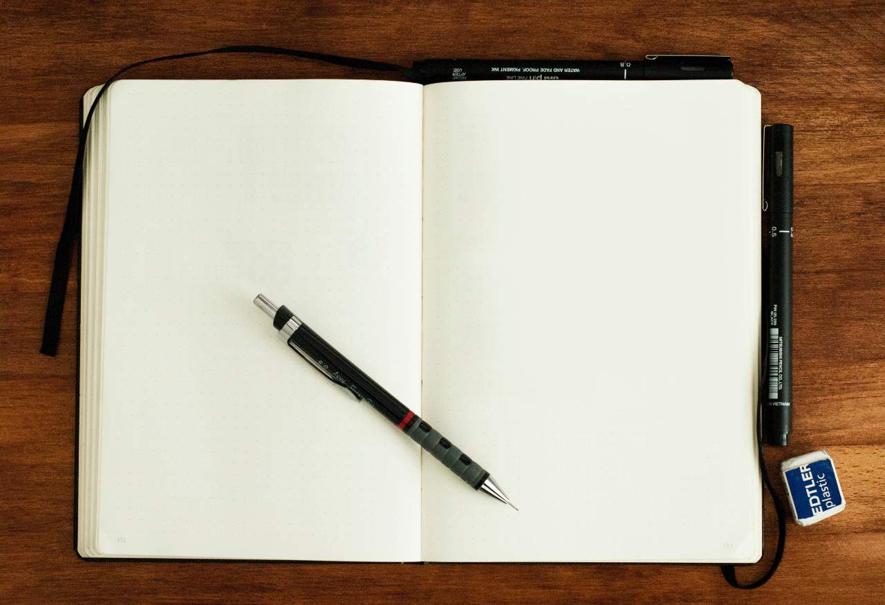 An open journal with a mechanical pencil on top.
