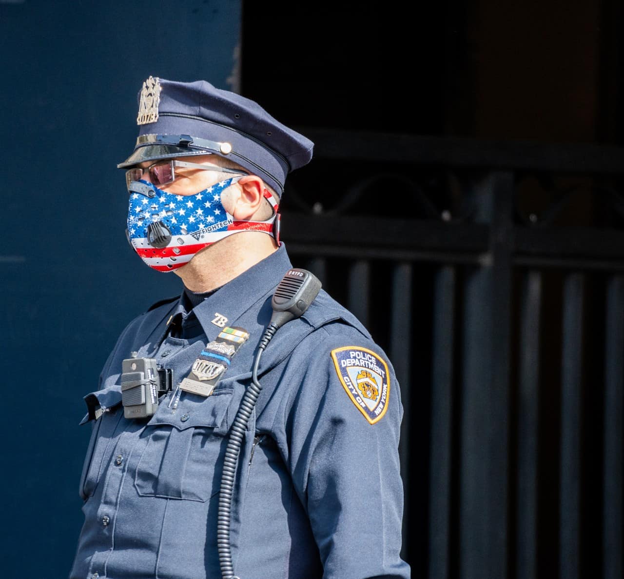 A police officer wearing a mask with the American flag on it.
