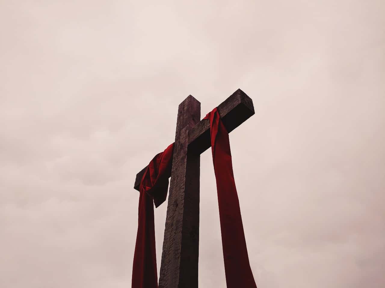 A cross with a scarlet sash draped on it.