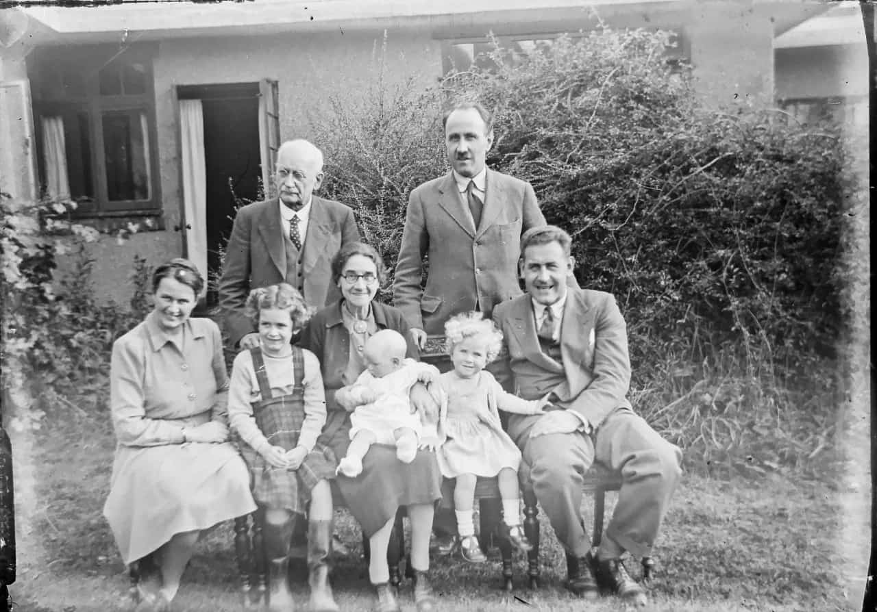 An old black and white photo of a family with three generations.
