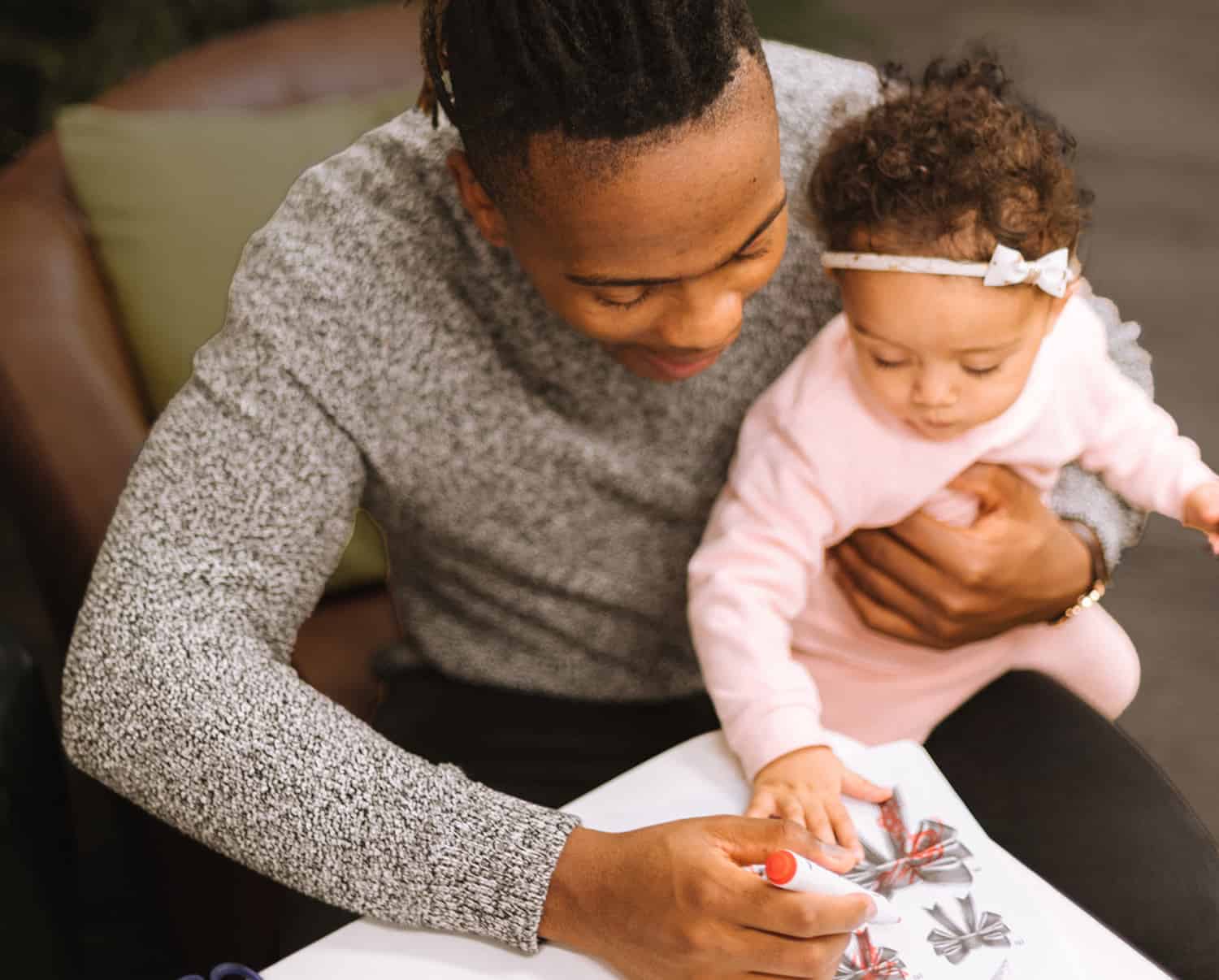 Photo of a daddy coloring with his daughter by Humphrey Muleba on Unsplash