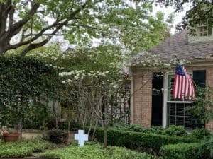 A house with an American flag and a "He is risen" sign.