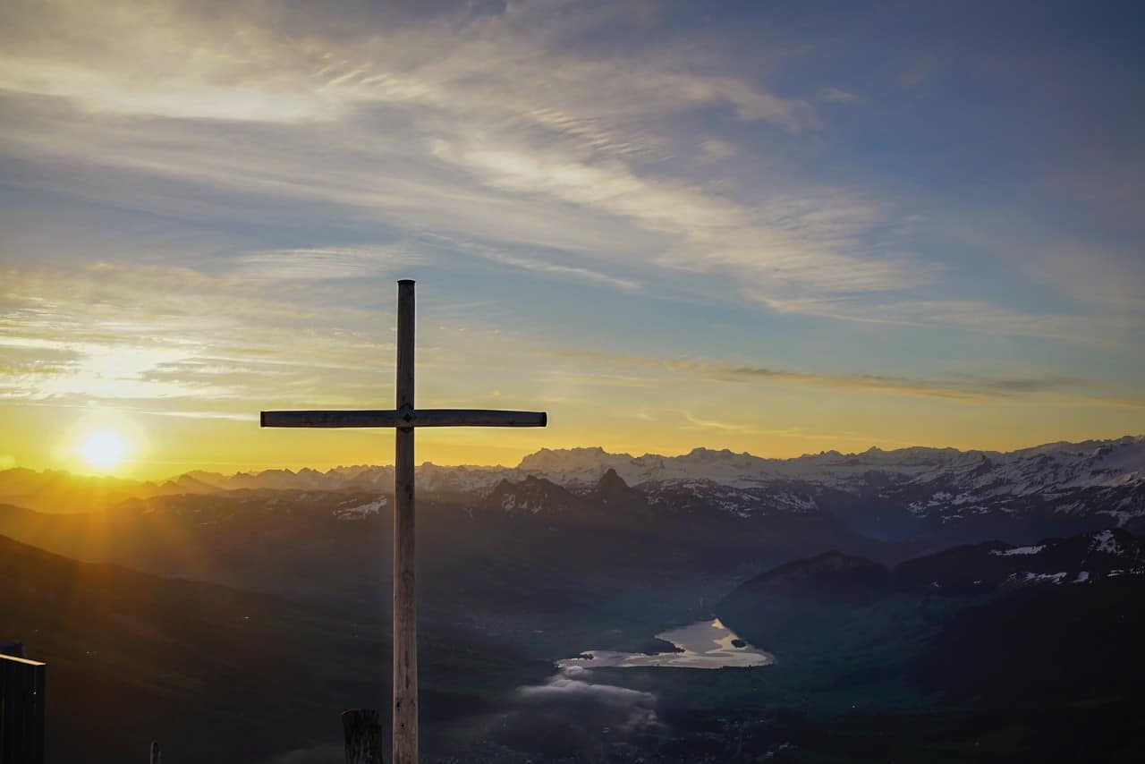 A cross on a hill at sunset.