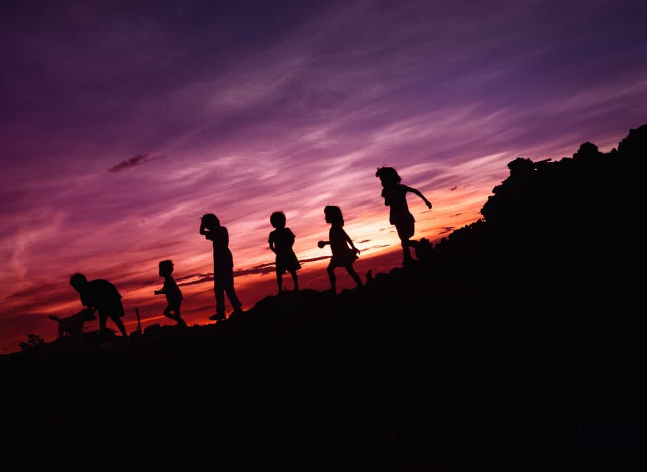 Silhouette of kids walking at sunset.