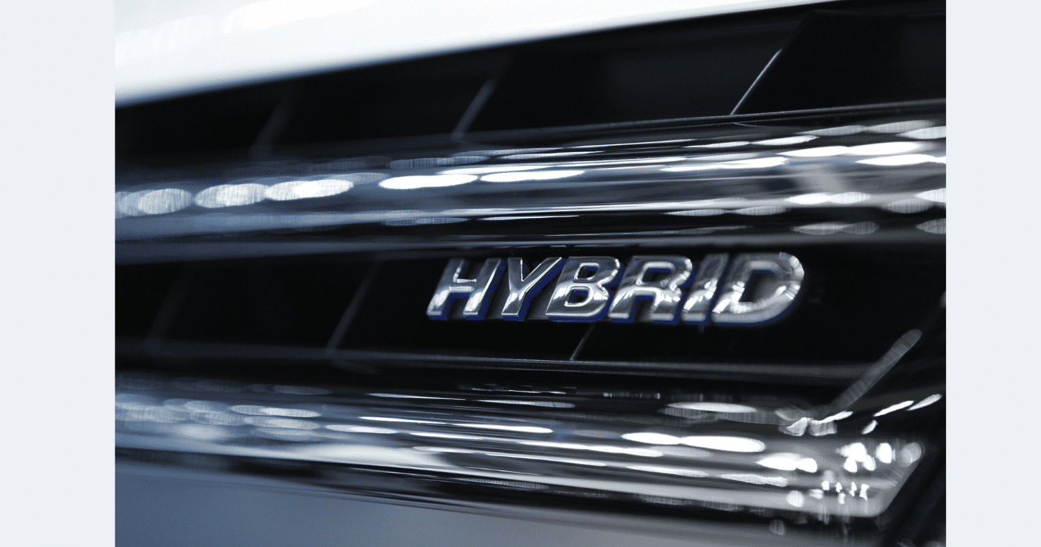 Grill of a hybrid car with the word "hybrid" on it.