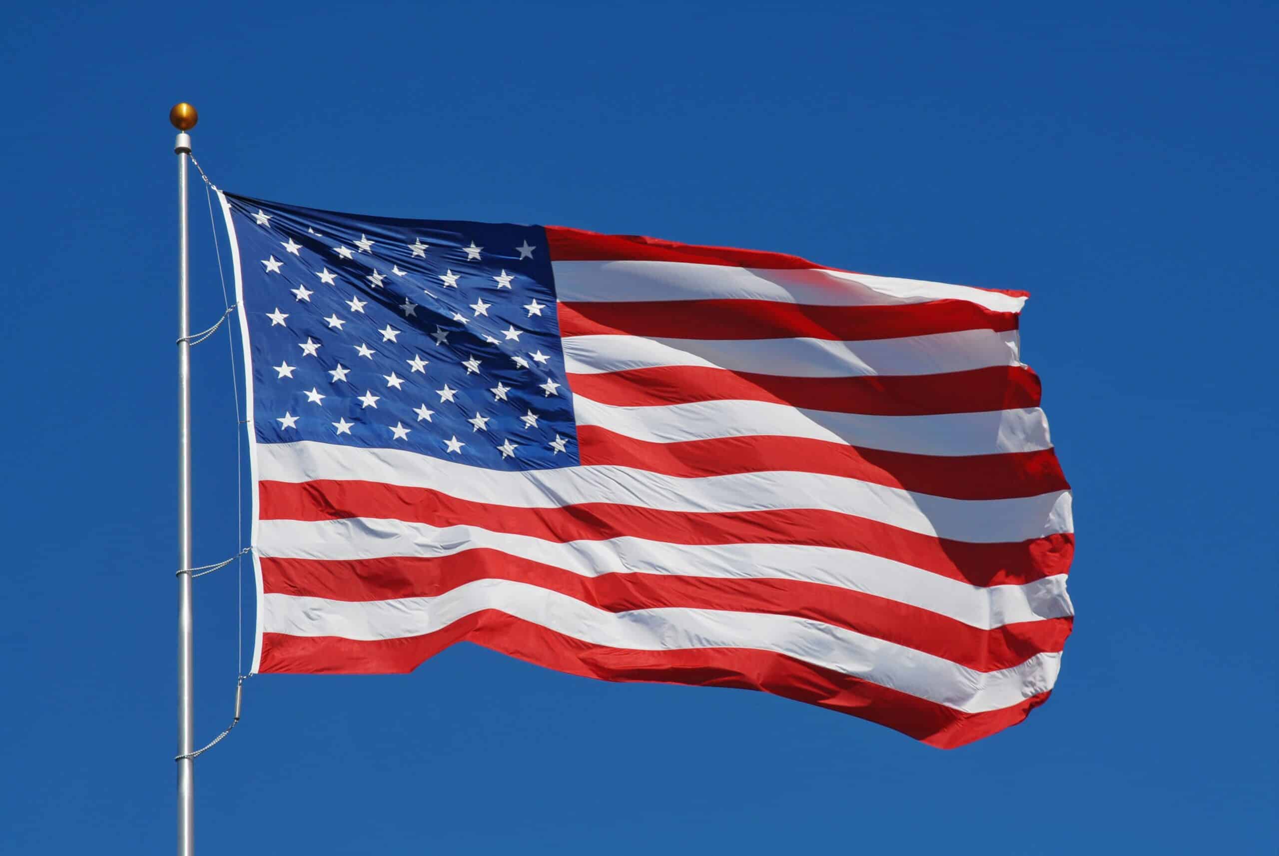 American flag with blue sky behind it.