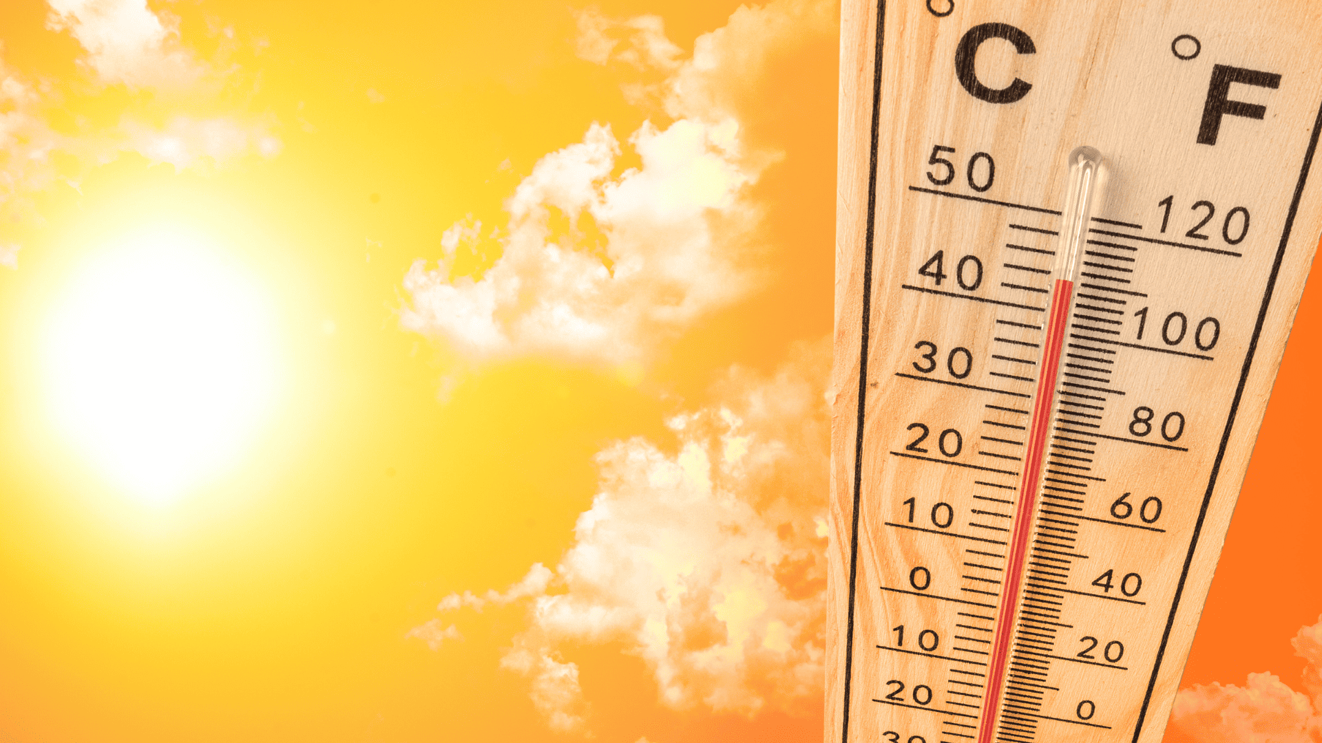 Thermometer showing 110 degrees with the bright sun on the left and orange background