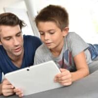 Father and child playing with digital tablet