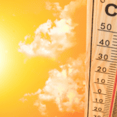 Thermometer showing 110 degrees with the bright sun on the left and orange background