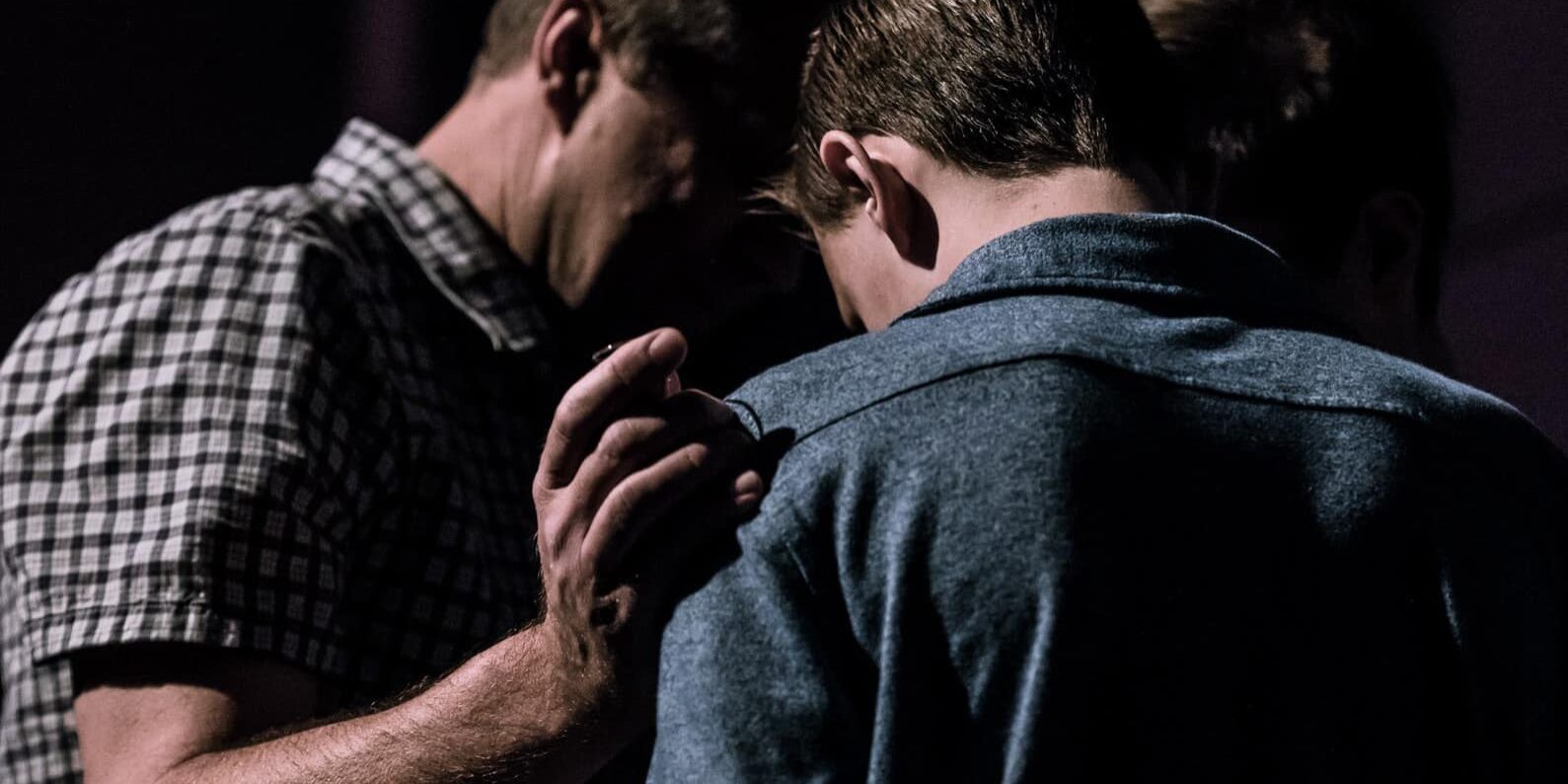 Men praying together.