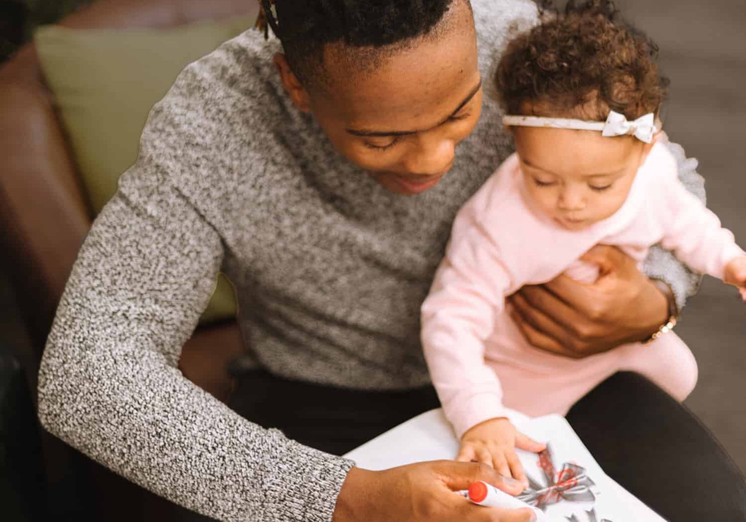 Photo of a daddy coloring with his daughter by Humphrey Muleba on Unsplash